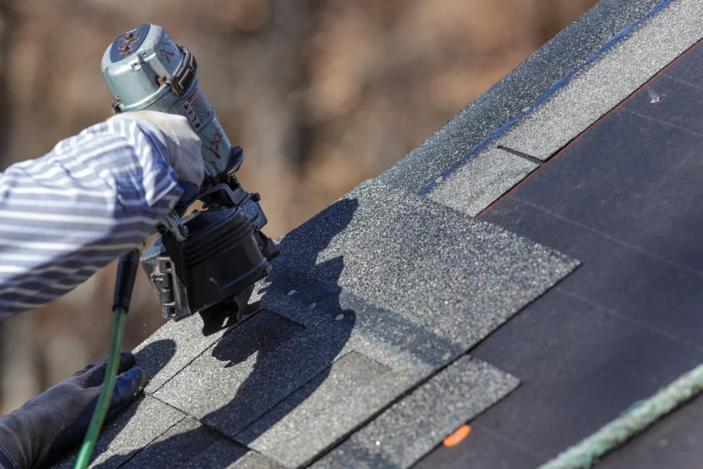 Close up view of roofing contractor nailing in shingles on Montgomery County home