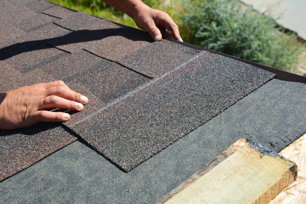 shingle roof cost- man placing shingle