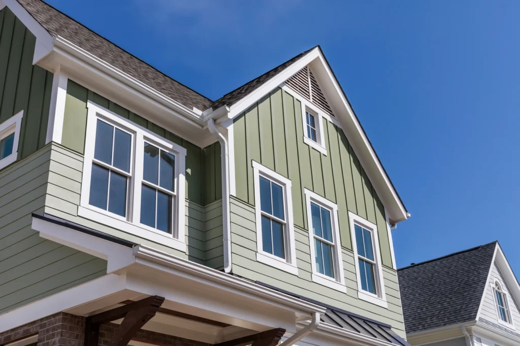 Close up of a modern house exterior with light green vertical siding in popular CertainTeed siding