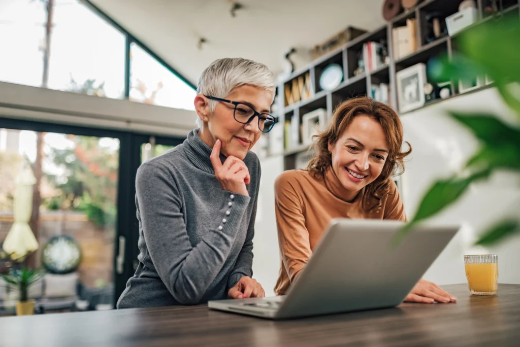 two woman looking at their computer