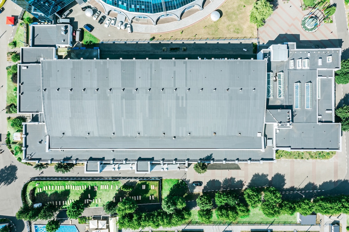 Aerial view of a large commercial building with a gray roof