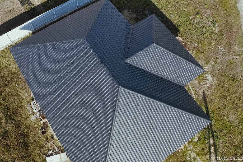 Aerial view of a house with a black, metal gable roof