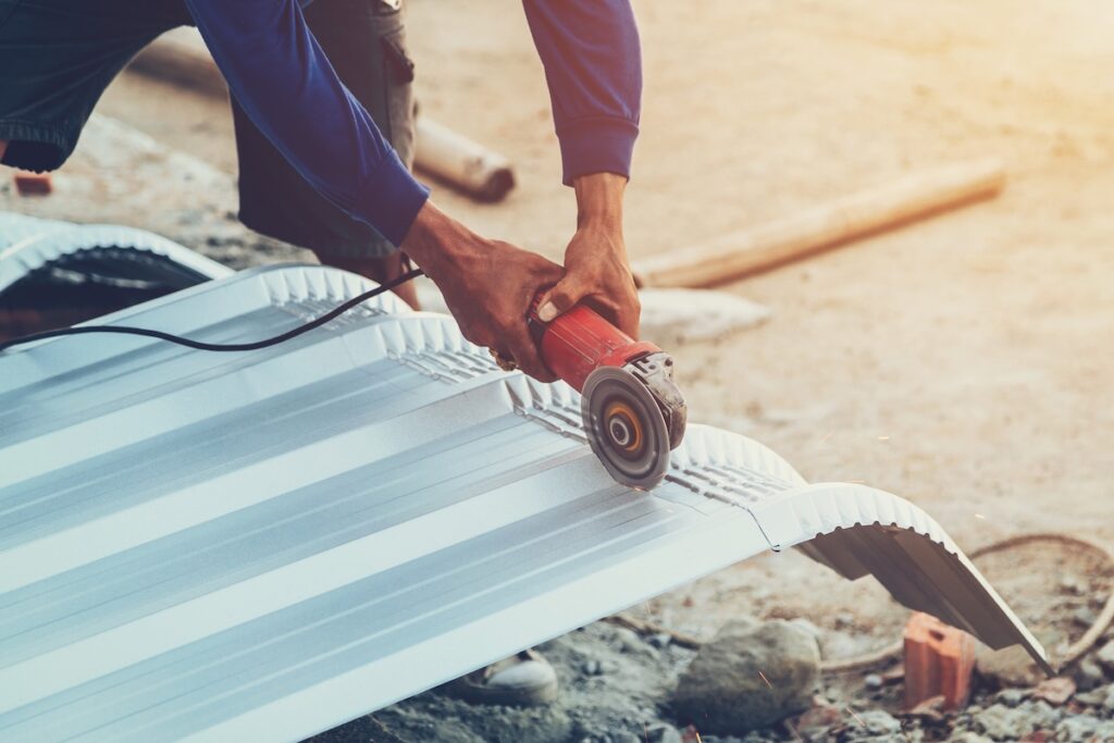 close up hand man use steel cutting to roof metal