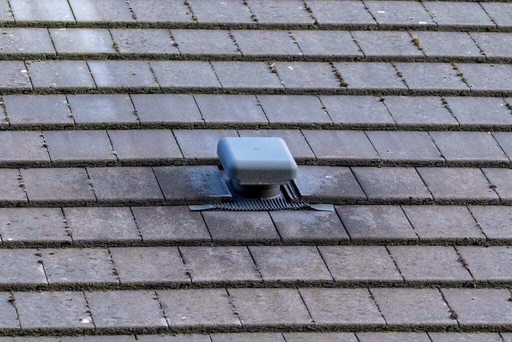 A portrait of a roof vent on a slate roof on a house. 