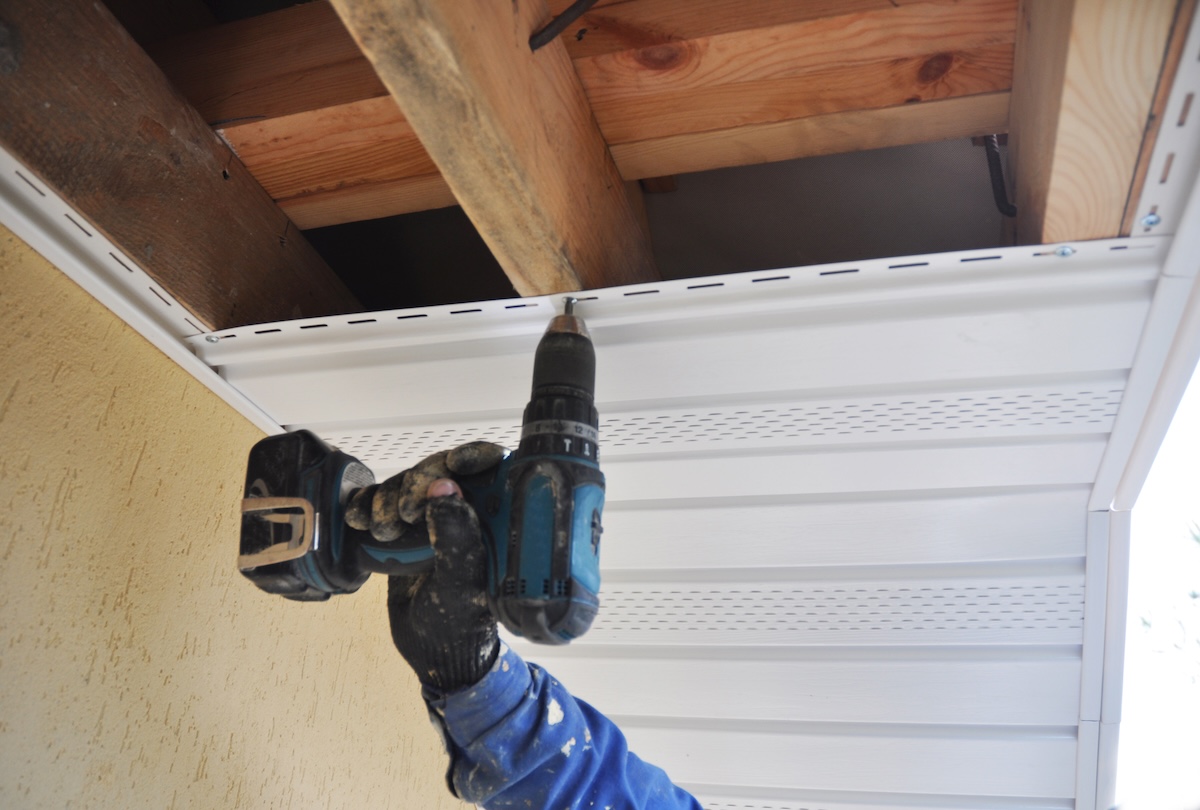 Roofer contractor installing on house roof new Soffit and Fascia. Roofing Construction. Soffit, Fascia installation.