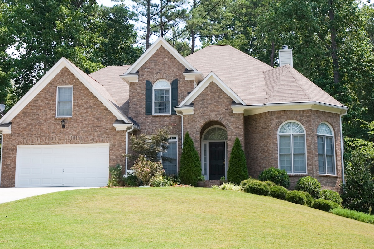 A nice brick house with fir trees on each side of the door